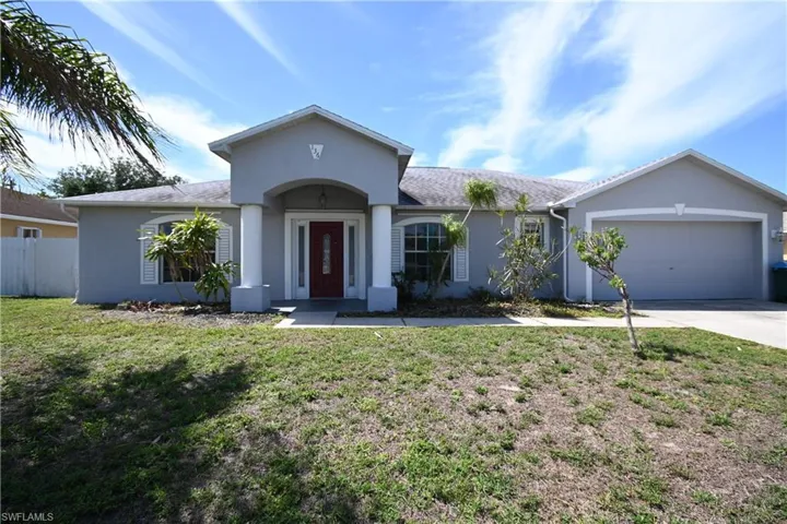Ranch-style home with stucco siding, an attached garage, and concrete driveway