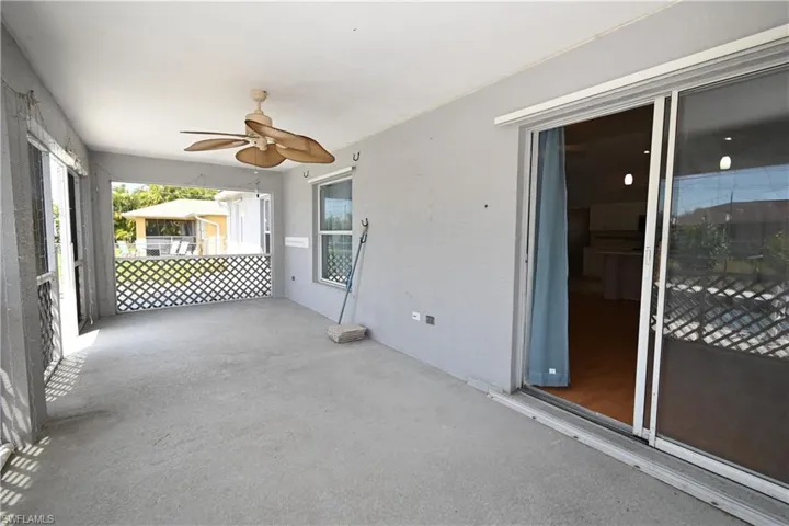 View of patio with a ceiling fan and a sunroom