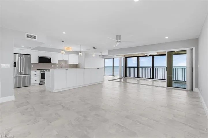 Unfurnished living room featuring ceiling fan, a water view, and recessed lighting