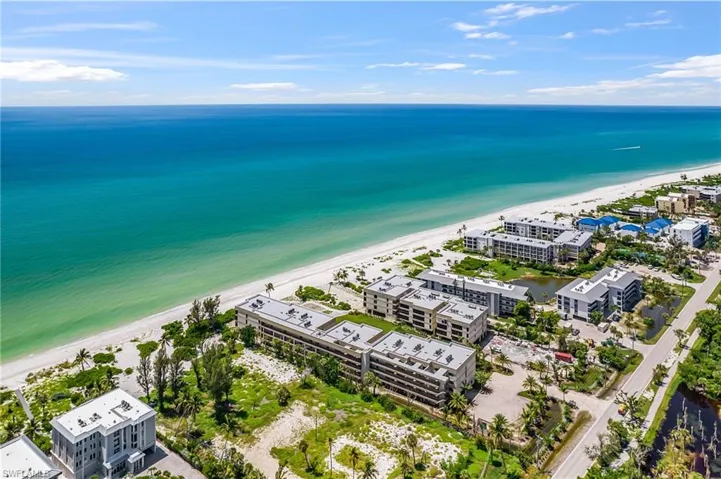 Aerial view of expansive beach and apartment complex / building
