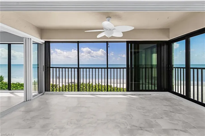Unfurnished sunroom with view of water and beach