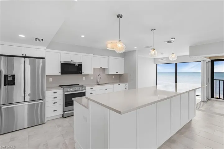 Kitchen featuring appliances with stainless steel finishes, white cabinets, pendant lighting, tasteful backsplash, and recessed lighting
