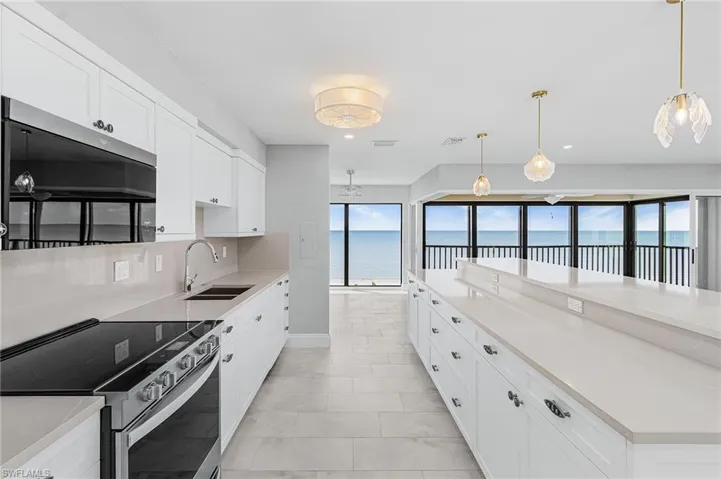 Kitchen featuring appliances with stainless steel finishes, white cabinetry, hanging light fixtures, backsplash, and recessed lighting