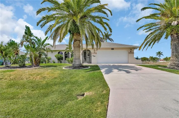 View of front of house featuring a front lawn, stucco siding, concrete driveway, and an attached garage