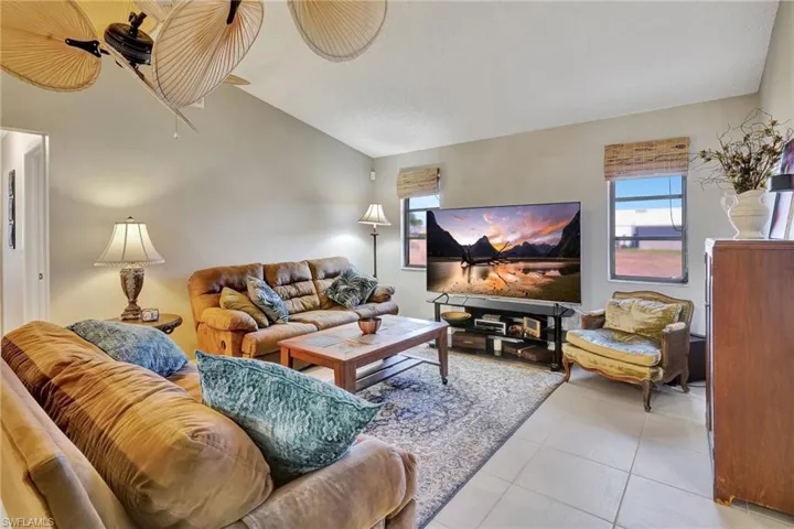 Living room featuring light tile patterned floors and lofted ceiling
