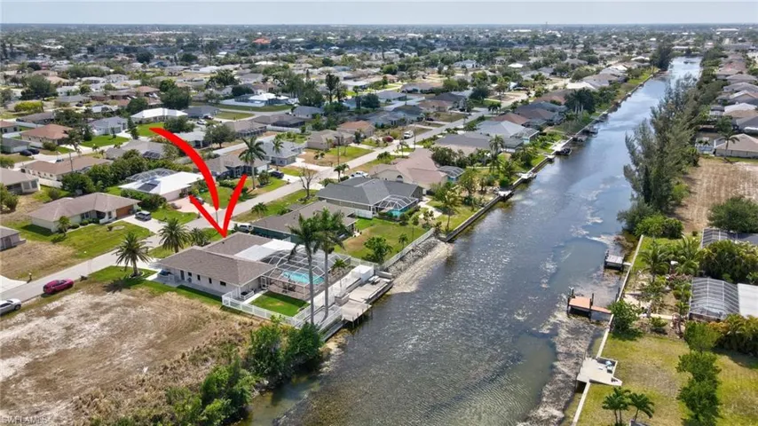 Birds eye view of property with a water view and a residential view