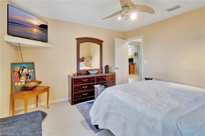 Bedroom with baseboards, visible vents, and a ceiling fan