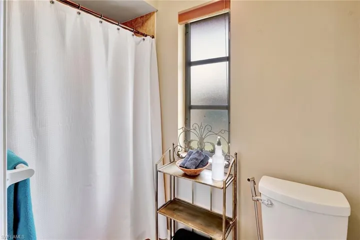 Full bath featuring toilet and a shower with shower curtain