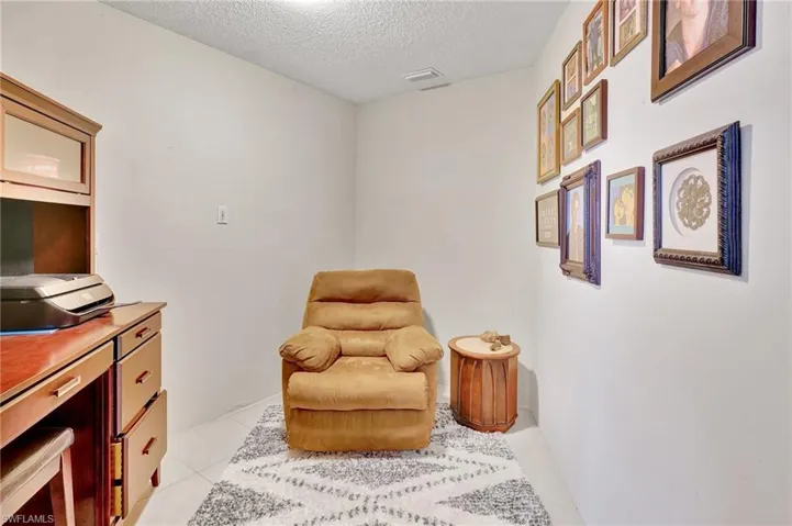 Sitting room featuring light tile patterned floors, a textured ceiling, and visible vents