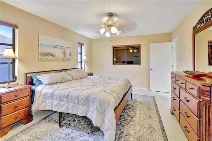 Bedroom with a textured ceiling and ceiling fan