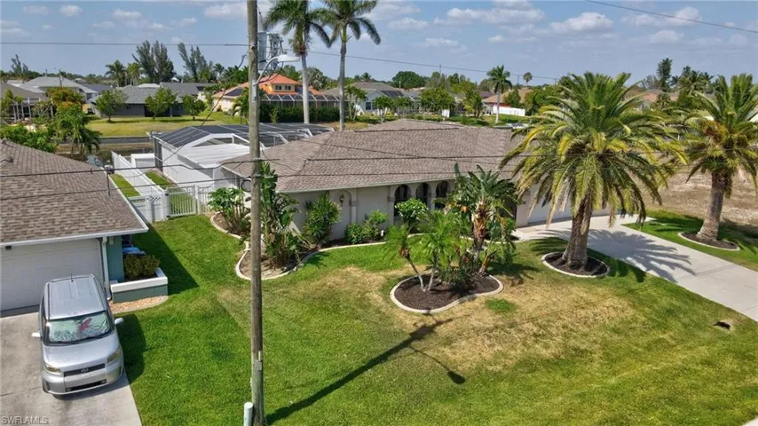 View of front of house featuring a front yard, a residential view, driveway, an attached garage, and fence