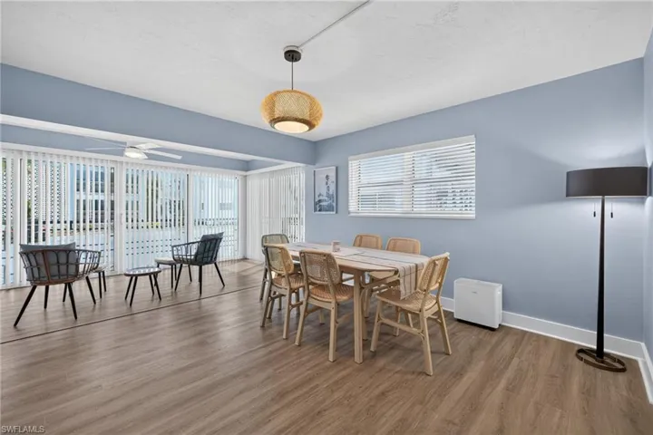 Expansive room featuring wood-finish flooring, a contemporary ceiling fan, and large sliding glass doors