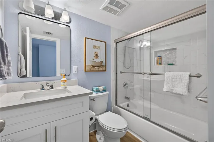 Vanity with integrated sink, contemporary mirror, and a three-light fixture
