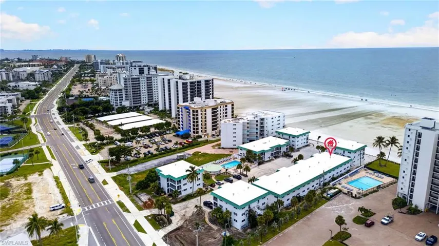 Coastal property with direct beach access, multiple residential buildings, and two outdoor swimming pools