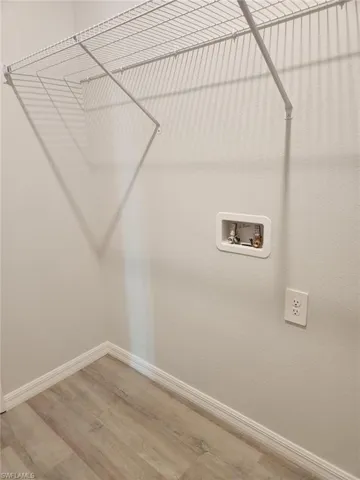 Laundry room featuring light wood-type flooring and hookup for a washing machine
