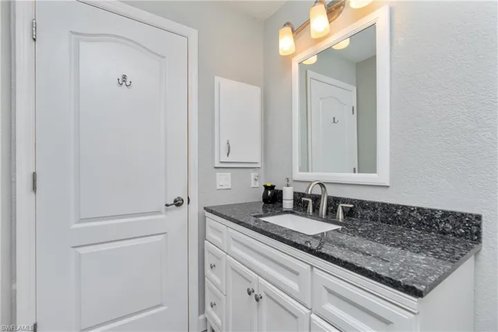 Bathroom with a textured wall and vanity