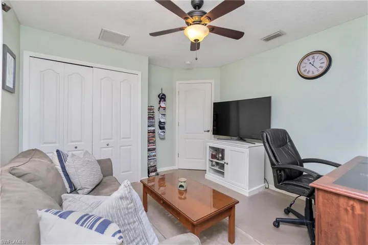 Living room featuring baseboards, visible vents, and a ceiling fan