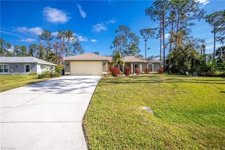Single story home with a garage, driveway, and a front yard