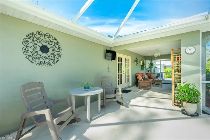 View of patio with french doors, ceiling fan, and a lanai
