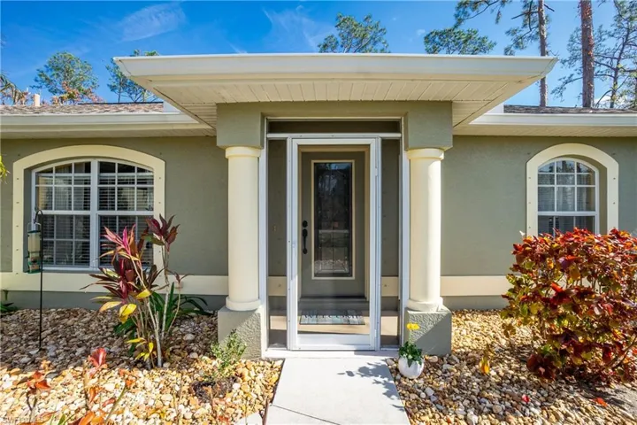 Doorway to property featuring stucco siding