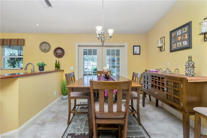 Dining area featuring baseboards, a notable chandelier, visible vents, and a wealth of natural light