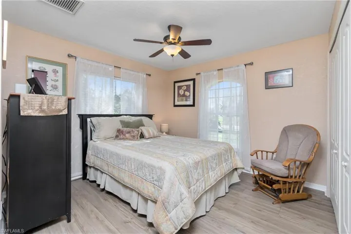 Bedroom featuring a closet, visible vents, light wood-style floors, a ceiling fan, and baseboards