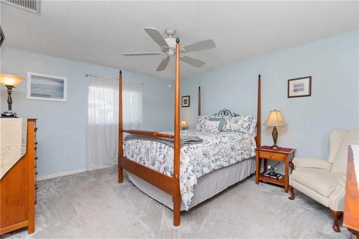 Bedroom with ceiling fan, carpet, visible vents, and baseboards