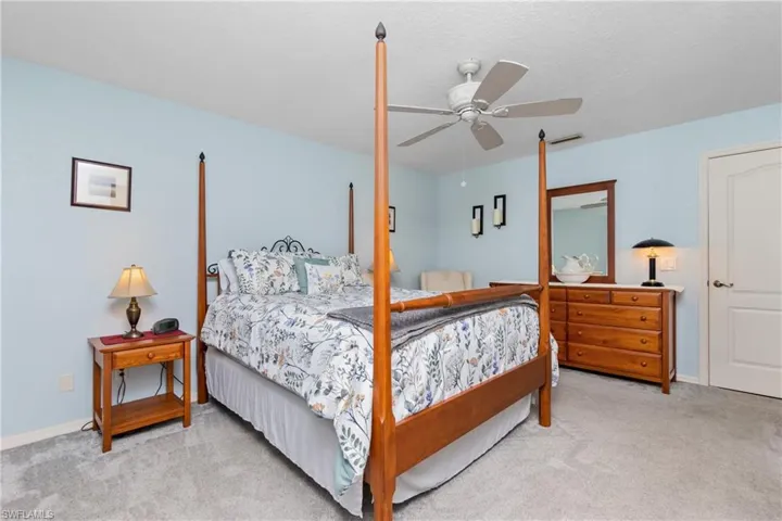 Carpeted bedroom with visible vents, a ceiling fan, and baseboards