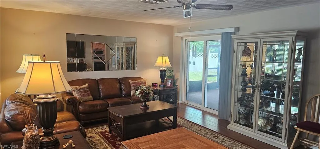 Rear view of property featuring a sunroom, stucco siding, and a patio