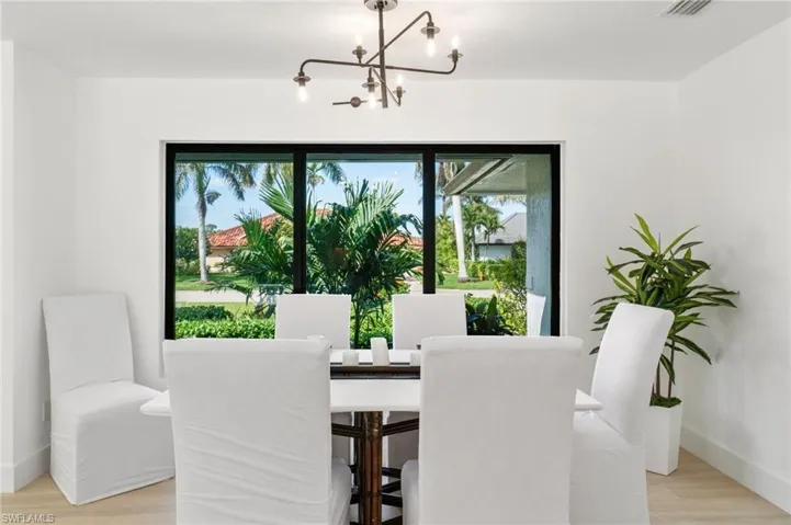 Dining room with a notable chandelier, and light wood-style flooring