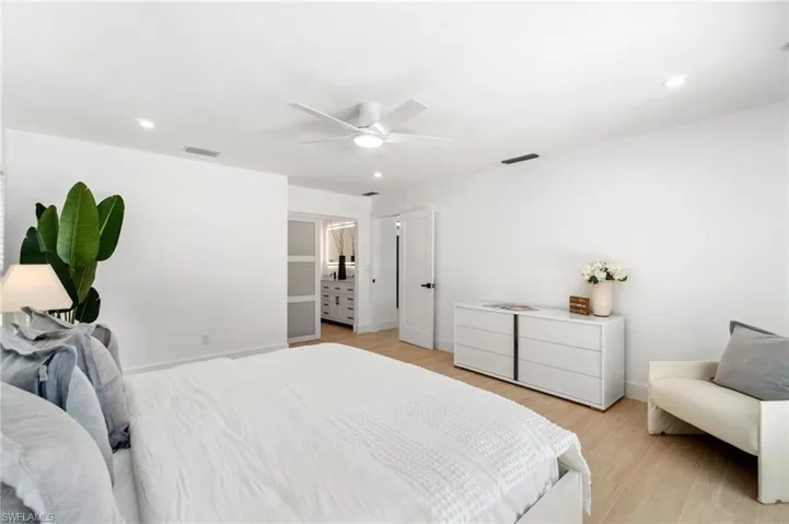 Primary bedroom featuring ceiling fan, light wood-type flooring, and recessed lighting