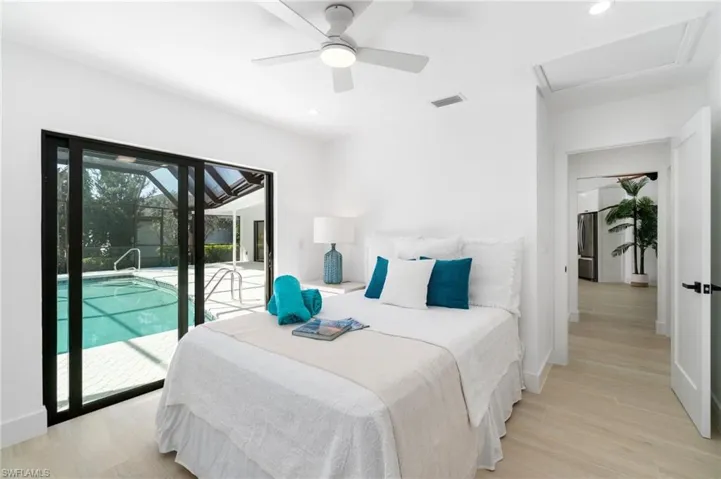 Guest Bedroom with queen-sized bed featuring recessed lighting, light wood-style floors, and access to exterior lanai