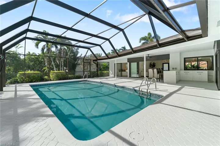 Outdoor pool with a lanai, a patio area, and ceiling fan