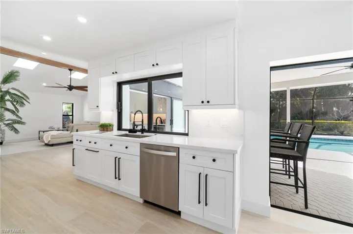 Kitchen featuring a sink, white cabinetry, quartz countertops and backsplash, and dishwasher