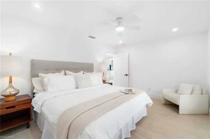 Guest bedroom featuring a king-sized bed, recessed lighting, and light wood-style floors