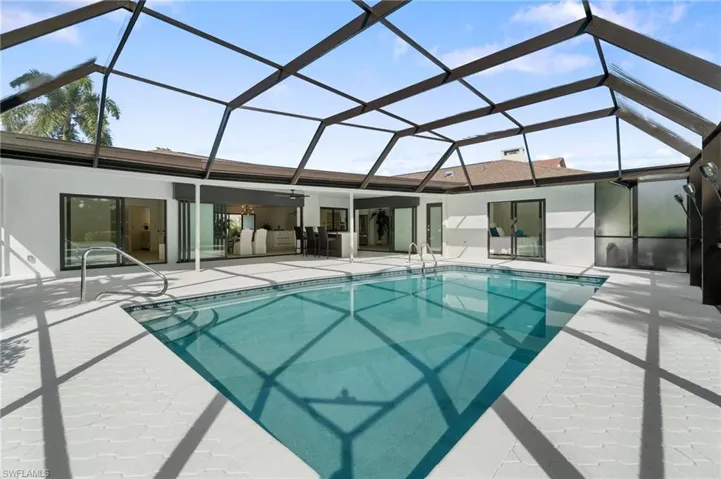 Outdoor pool with screen enclosure and a patio area
