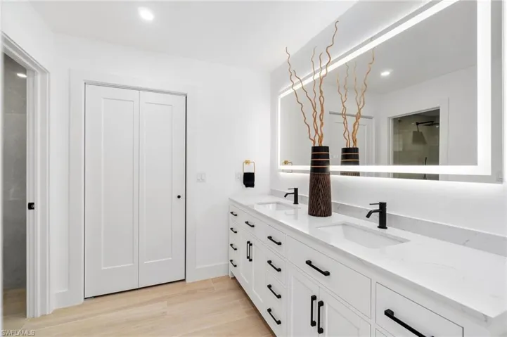 Primary bath featuring double vanity, recessed lighting, a sink, and wood finished floors