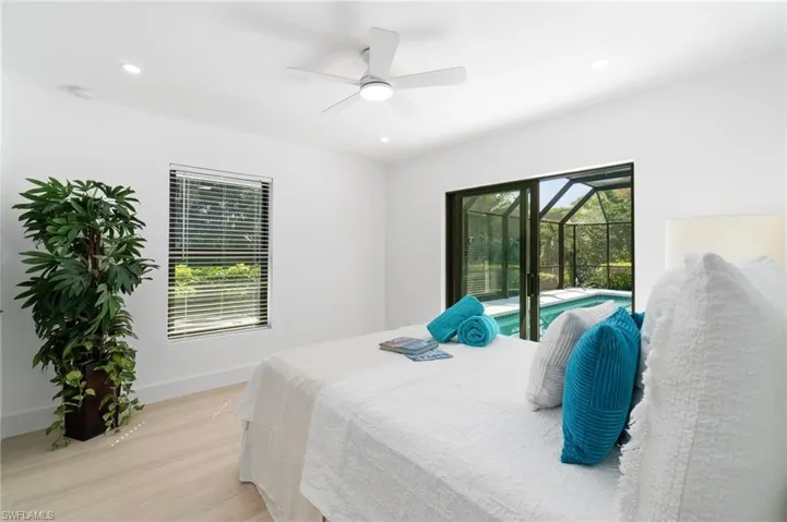 Guest bedroom with queen-sized bed, access to exterior lanai, recessed lighting, and light wood-style flooring