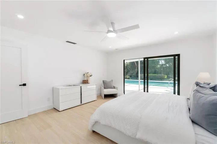 Primary bedroom featuring access to exterior lanai, recessed lighting, light wood-style floors, and upgraded baseboards
