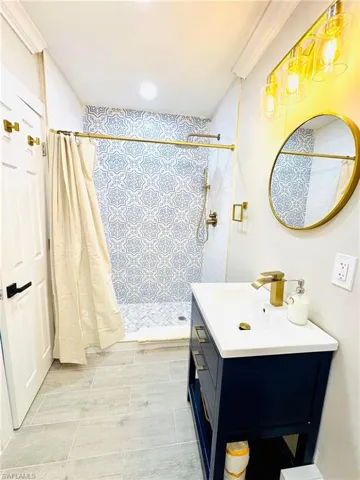 Full bath with a shower stall, vanity, and recessed lighting