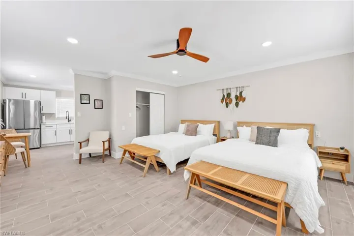Bedroom featuring freestanding refrigerator, a closet, recessed lighting, ornamental molding, and ceiling fan