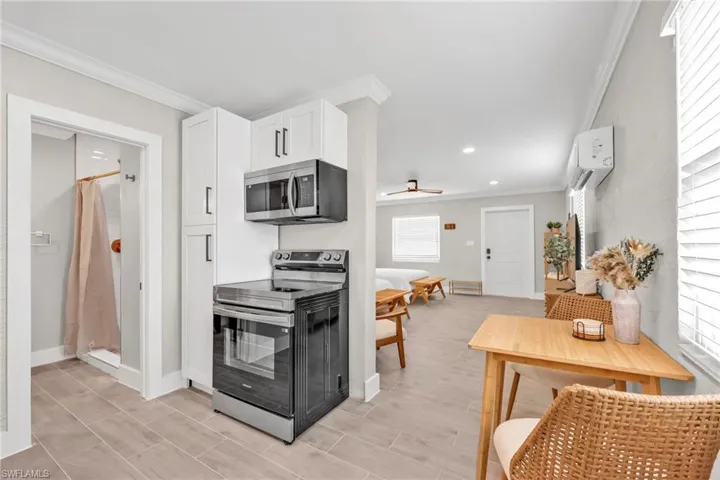 Kitchen featuring appliances with stainless steel finishes, crown molding, recessed lighting, white cabinets, and ceiling fan