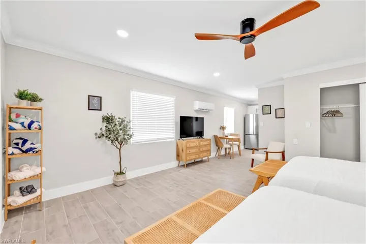 Bedroom featuring freestanding refrigerator, ornamental molding, a ceiling fan, a closet, and recessed lighting