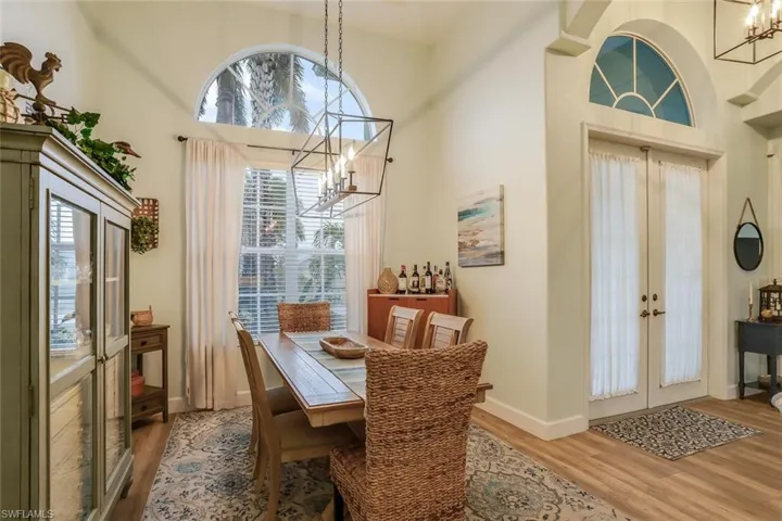 Dining area with hanging lights, a high ceiling, and wood finished floors