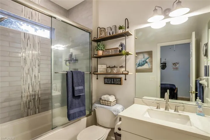 Full En Suite bathroom featuring vanity, bath / shower combo with glass door, and ensuite bathroom