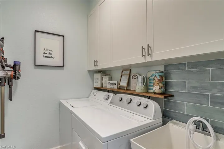 Laundry area with independent washer and dryer with plenty of cabinet space.