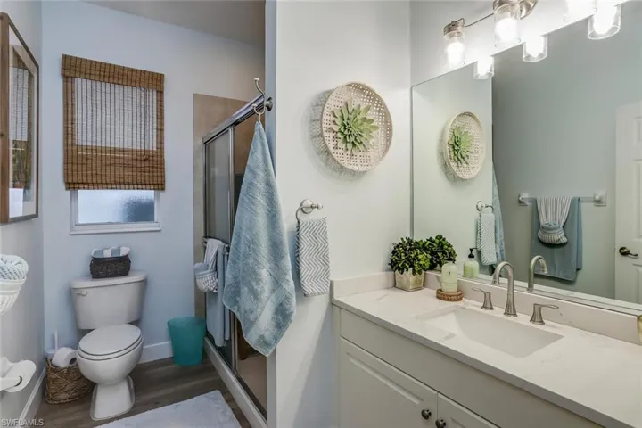 Guest Bathroom with vanity, a shower stall, and dark wood finished floors