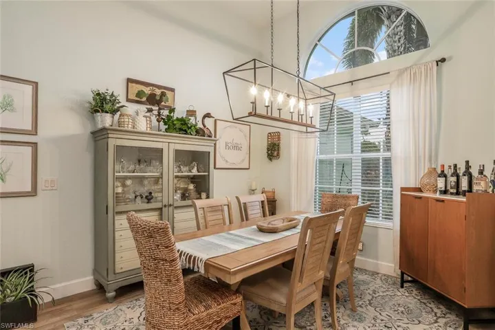 Formal Dining with a chandelier, light wood-style flooring, and a high ceiling