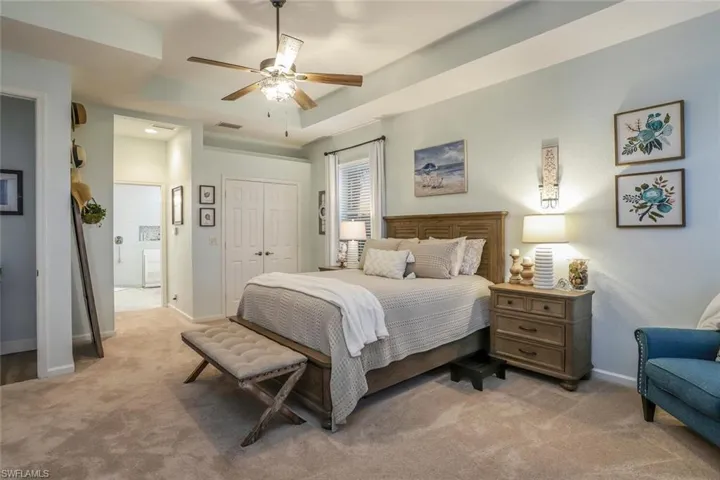 Owners Suite with two closets, a ceiling fan, Brand New carpet, a tray ceiling