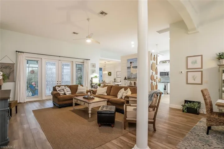 Living/Family room featuring a ceiling fan, French doors leading to pool, and wood finished floors